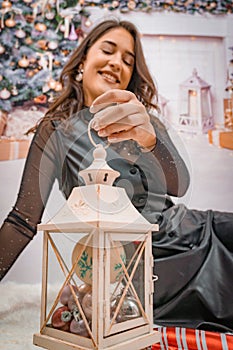 woman decorating her lantern in front of the christmas tree