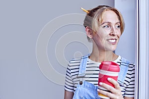 Woman Decorating Room At Home Taking A Break With Hot Drink In Reusable Cup