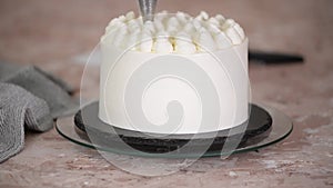 Woman decorating whipped cream on cake.
