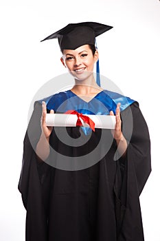 A woman with a degree in her hand as she looks at the camera