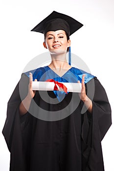 A woman with a degree in her hand as she looks at the camera