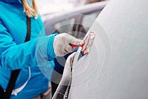 Woman deicing rear car windshield