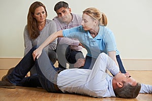 Woman Demonstrating Recovery Position In First Aid Training Clas