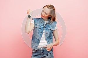 Woman in denim vest showing smartwatch
