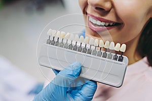 Woman in dentist chair choosing tooth implants