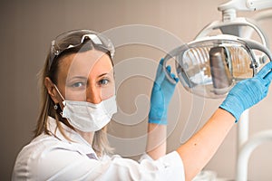 A woman dentist doctor holding a lamp in dental clinic