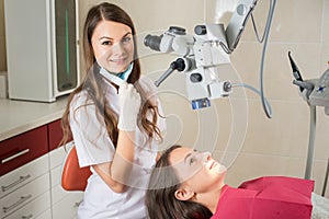 Woman dentist in her office treating female patient