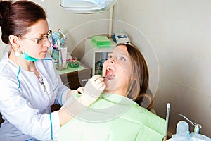 Woman dentist making a review of patient mouth