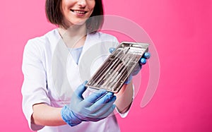 Woman dentist opens a package of sterile dental instruments