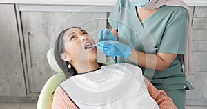Woman, dentist and patient with clinic tools for cleaning mouth, oral or gum in dental care. Face of Asian or female