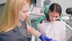 Woman Dentist Performs Treatment Procedure on Female Patient in Dental Clinic