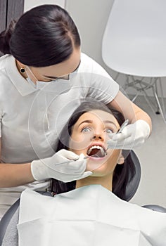 woman in the dentist's chair is looking frightened