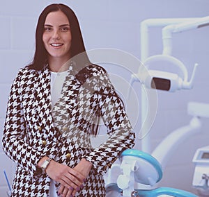 Woman dentist standing in her office smiling