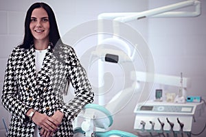 Woman dentist standing in her office smiling