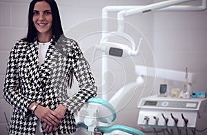 Woman dentist standing in her office smiling