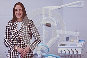 Woman dentist standing in her office smiling