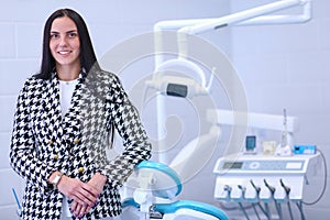 Woman dentist standing in her office smiling