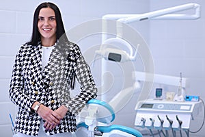 Woman dentist standing in her office smiling