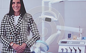 Woman dentist standing in her office smiling