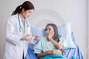 Woman dentist talking with her female patient explain with tooth model and preparing to treatment at dentalcenter