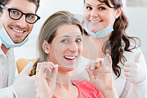 Woman at dentist using dental floss