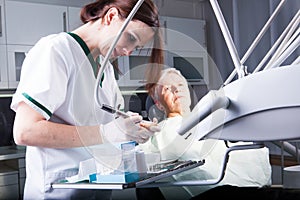 Woman dentist on work with a elder patient in dental clinic
