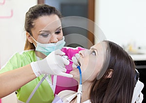 Woman dentist working on her patient's teeth