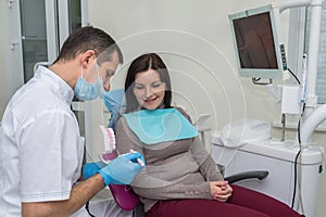Woman in dentistry pointing at teeth sampler