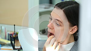 Woman in dentistry removes silicone teeth trainer from her mouth by herself.