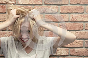 A woman in depression tears her hair. Women`s problems, stress, trouble