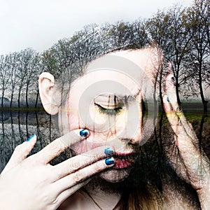 A woman with depression who has been suffering from abuse and forest lake background. Conceptual image showing depression,