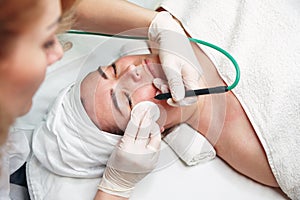 Woman dermatologist surgeon preparing a professional electrocautery