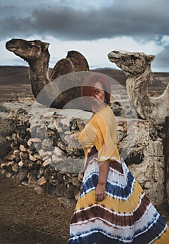 Woman in a desert landscape with camels