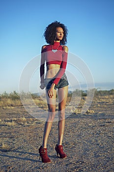 Woman in desert location wearing denim shorts.