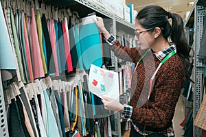 Woman designer choosing clothing sample drapery