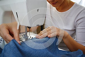 Woman designer. Seamstress at the sewing machine. Tailoring. Factory textiles