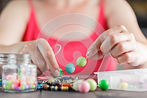 Woman designing colorful necklace with plactic beads