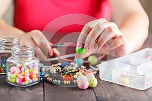 Woman designing colorful necklace with plactic beads