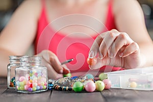 Woman designing colorful necklace with plactic beads