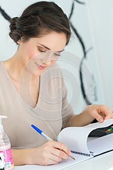 Woman at desk writing in notebook