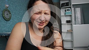 Woman desperate at home. Victim of Abuse Violence. Caucasian girl with long brown hair crying in her room with blue and white. Fat