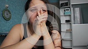 Woman desperate at home. Victim of Abuse Violence. Caucasian girl with long brown hair crying in her room with blue and white. Fat