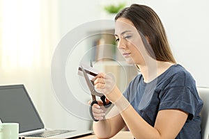 Woman destroying a credit card at home photo