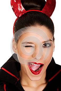 Woman in devil costume blinks eye. photo