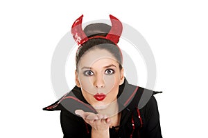 Woman in devil costume blowing a kiss.