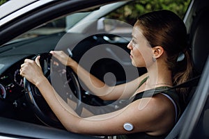 Woman with diabetes monitoring her blood sugar during car drive.