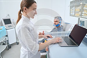 Woman diagnostician at the workplace conducts EEG - electroencephalography