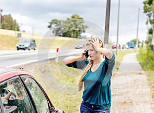 Woman dialing her phone after car crash