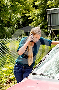 Woman dialing her phone after car crash