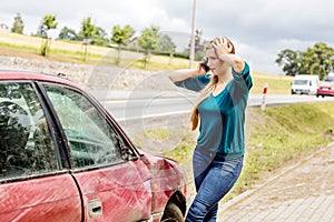 Woman dialing her phone after car crash